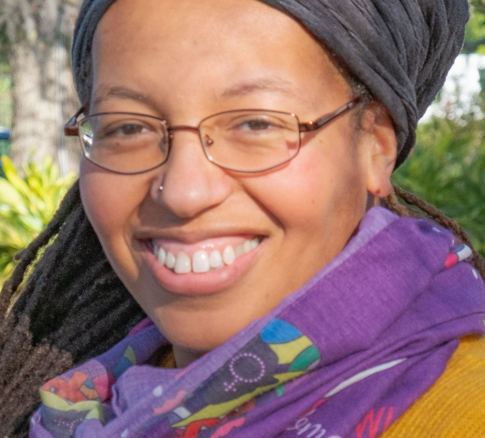 Photo of Olivia G Ford wearing glasses, smiling